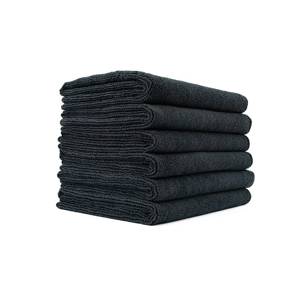 A stack of black Spa and Workout towels on a white background.