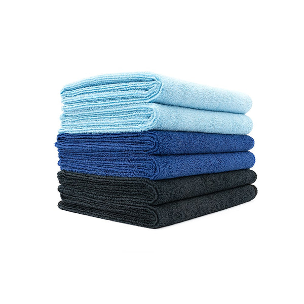 A stack of different shades of blue Spa and Workout towels on a white background.
