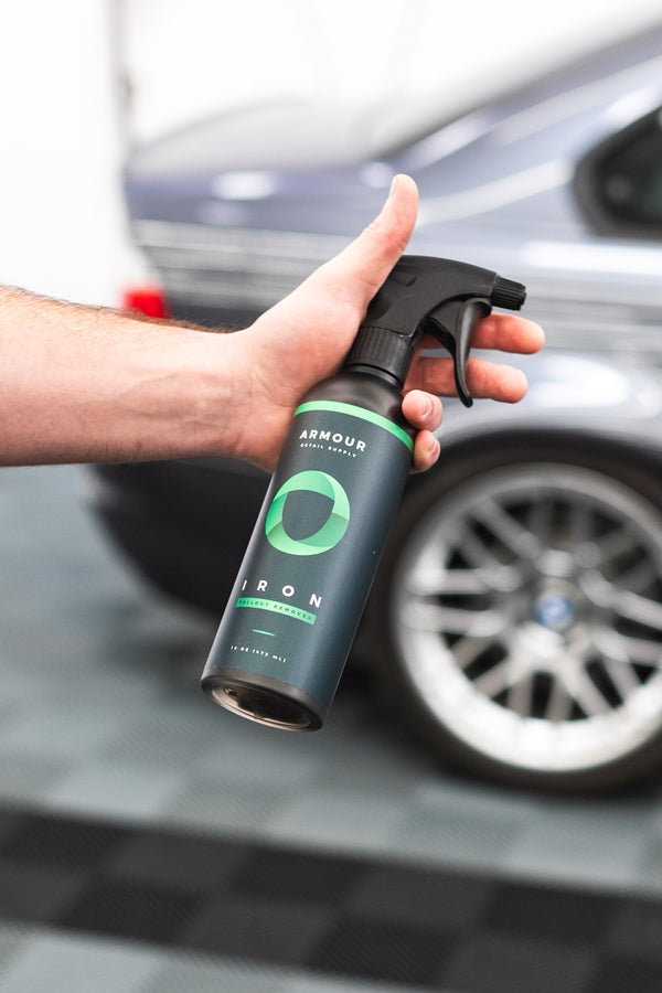 Armour Detail Iron 16oz bottle with a grey car in the background.