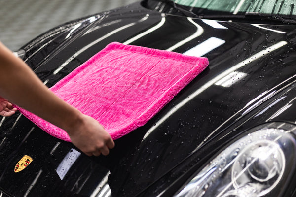 A person using an Armour Detail Supply M22 on a black car.