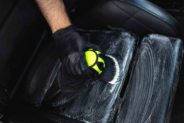 Person cleaning car seat interior with a Detail Factory Curveball Ectoplasm.