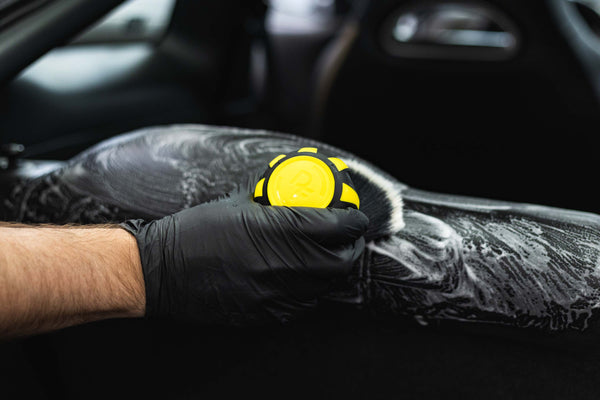 Person cleaning car interior with a Detail Factory Curveball Livewire.