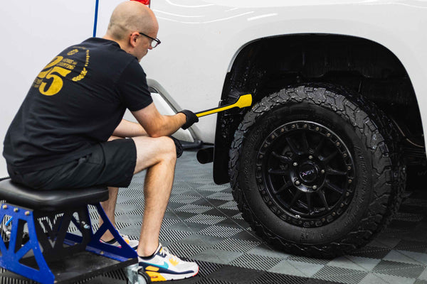 Detail Factory Fender Well Brush Livewire scrubbing the fender wall of a white truck.