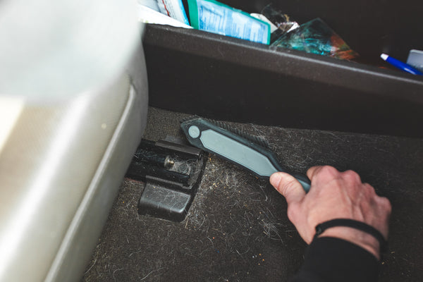 A hand cleaning the back of a car with the Detail Factory Pet Hair Brush.