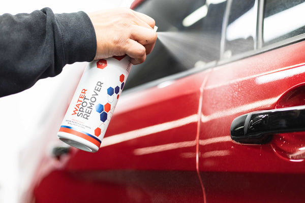 Gtechniq W9 Water Spot Remover sprayed into door panel of a red Ford Explorer.