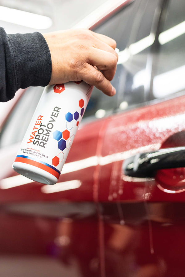 Gtechniq W9 Water Spot Remover sprayed into door panel of a red Ford Explorer.