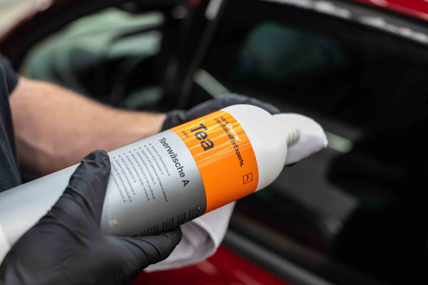 A person placing a dollop of Koch Chemie Tea on a corner of a detailing towel.
