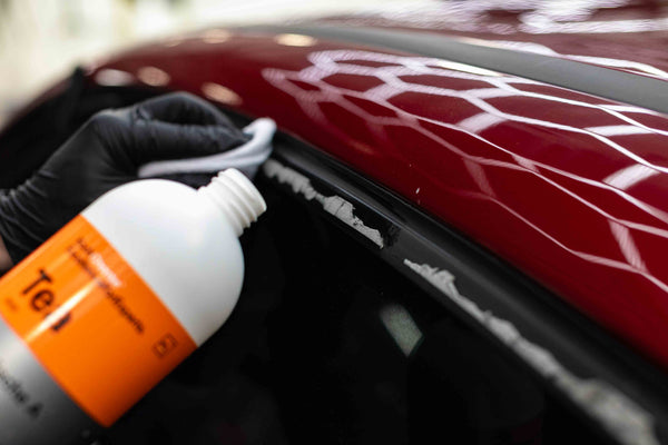 A person rubbing Koch Chemie Tea into the edge of a car door frame.