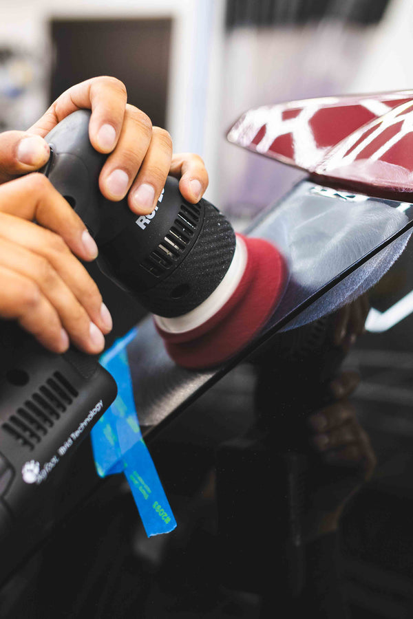 P&S Rehab being on a maroon polishing pad connected to a rupes polisher being used on a car.