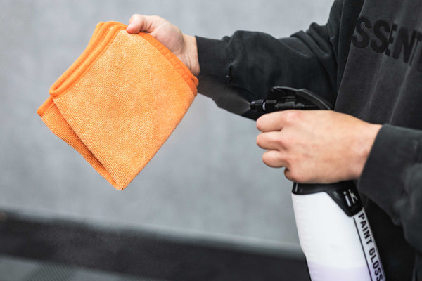 Person holding an orange FTW and an iK spray bottle.