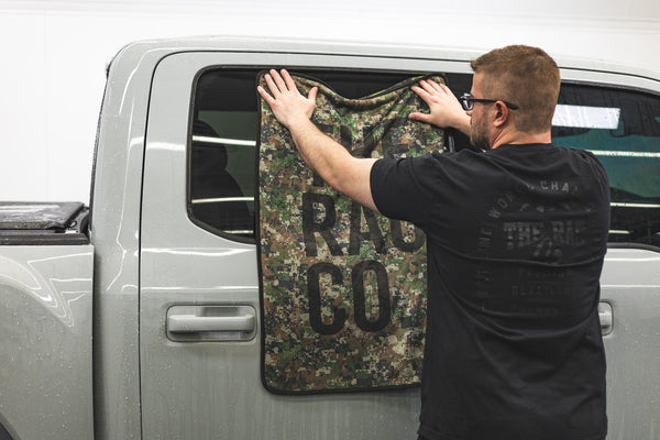 Slim Dryer Digital Camo towel being used to wipe down the window of a Ford Raptor.