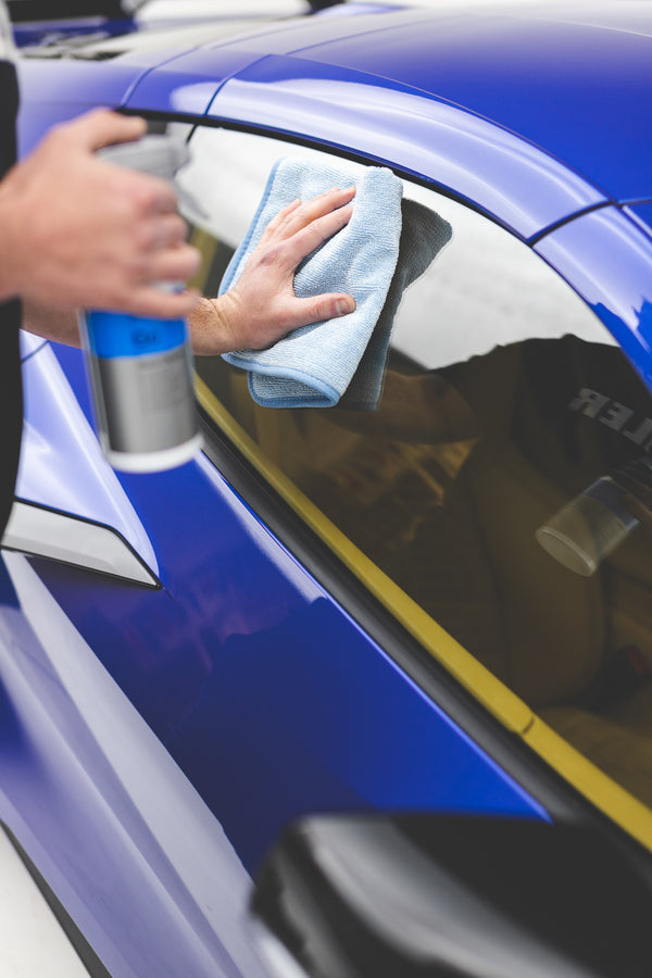 FTW 16 x 16 Light Blue towel wiping down window of blue C8 Corvette.