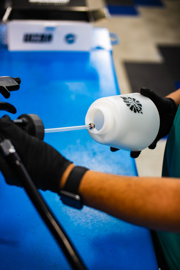 A person putting the sprayer of an Ultra Air Engine Blaster on its water reservoir.
