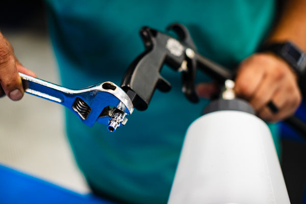 A person using a wrench to adjust the fitting of an Ultra Air Engine Blaster.