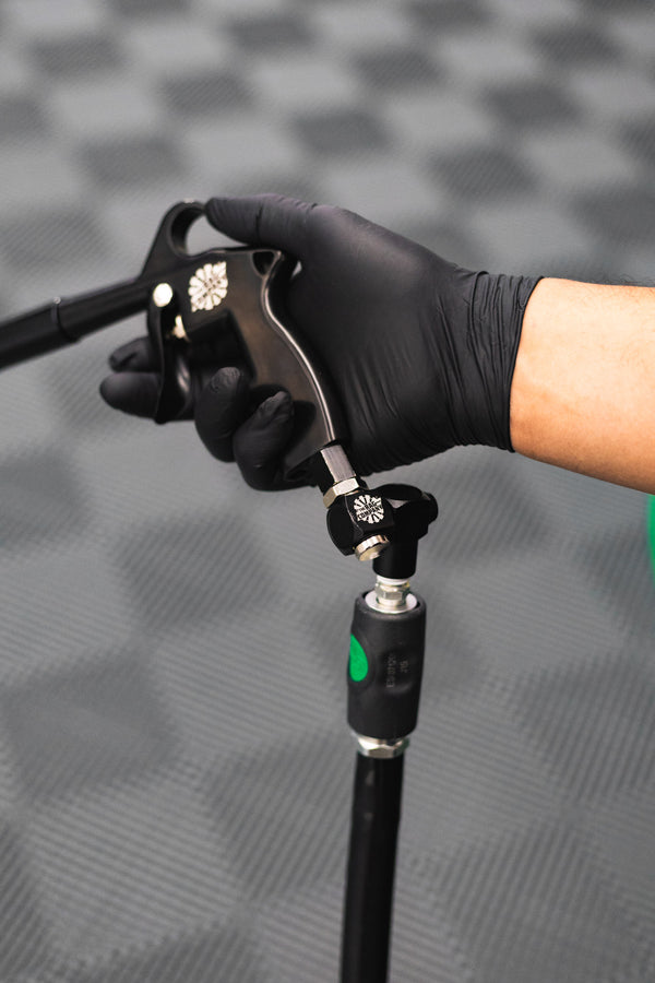 A closeup of a person holding a an Ultra Air Blaster using a Swivel attached to a hose.