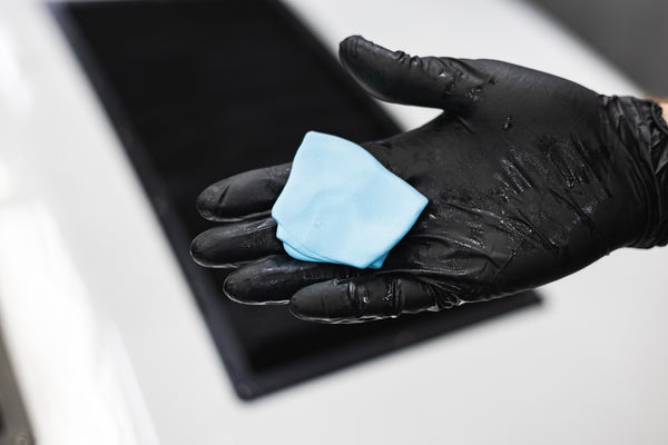 The Rag Company Ultra Clay Bar being held in a gloved hand.