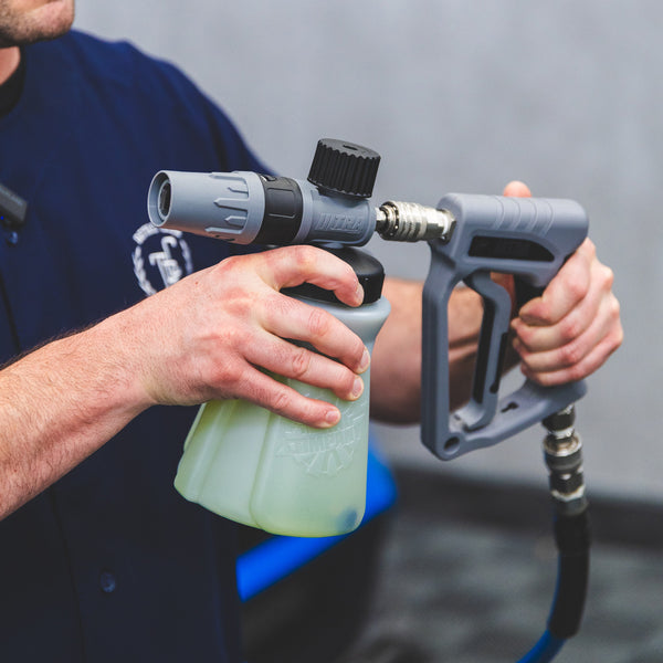A person connecting a TRC Ultra H2O Foam Cannon to the TRC Ultra H2O Spray Gun.