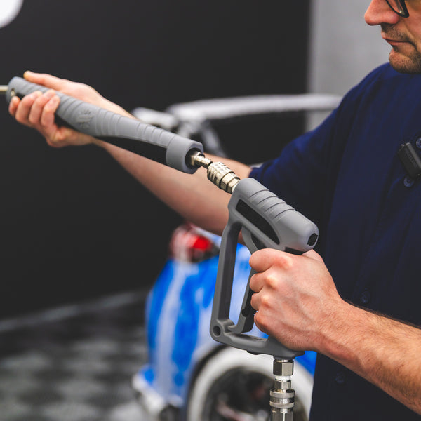 A close up of a person connecting a TRC Ultra H2O Spray Wand to a Spray Gun.