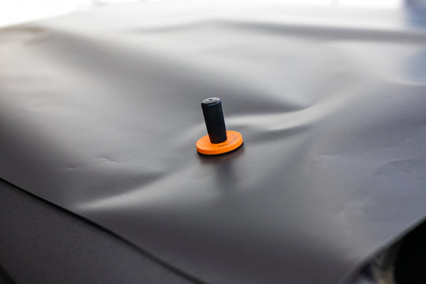 A close up of a Yellotools Speedmag on a car dent.