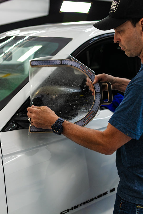 A person using the Yellotools Wrap U Ezee on a car side mirror.