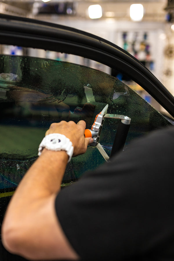 A person using the Yellotools Wetmaxx on a car window.