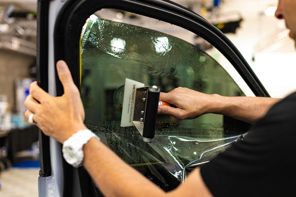 A person using the Yellotools Wetmaxx on a car window.