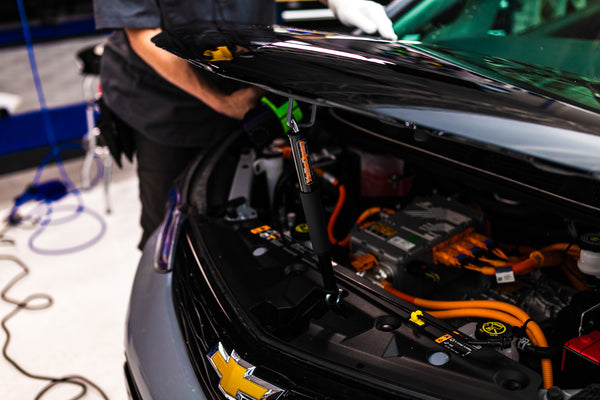 A demo of a Yellotools YelloOpen holding up the hood of a car.