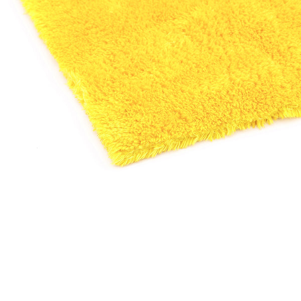 The corner of a yellow 16x16 Eagle Edgeless Towel from The Rag Company. Having no edges or tags prevents scratching paint or glass.