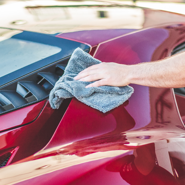 Using a grey Eagle Edgeless 600 towel to detail the exterior of a red Ford GT