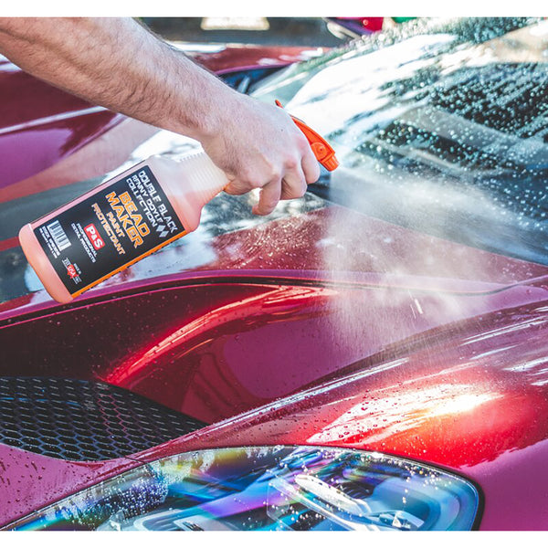 A closeup of a person spraying P&S Bead Maker on a maroon car hood.