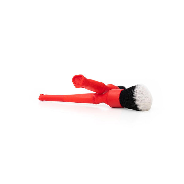 Two red Synthetic Detailing Brushes crossing on a white background.