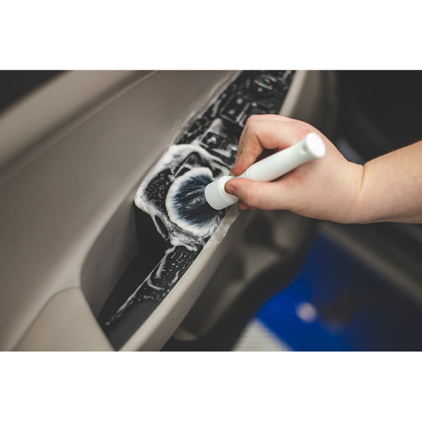 white detail factory detailing brush cleaning car door.