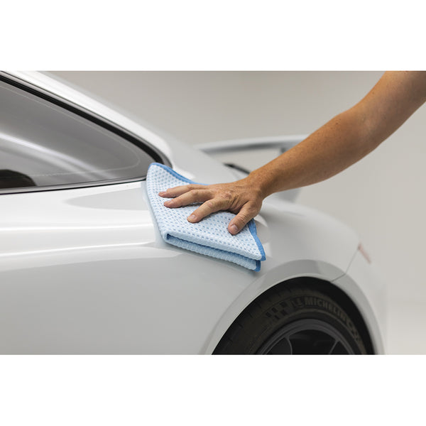 Using a light blue Dry Me A River towel from The Rag Company to wipe the side of a white Porsche 911 GT3 sports car