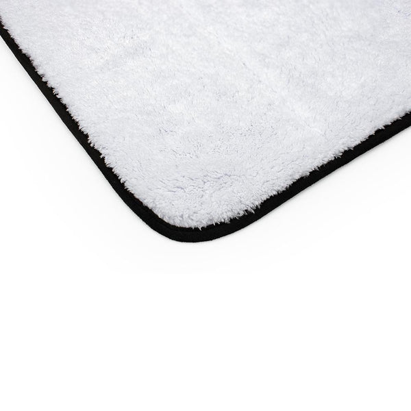 Corner of a white towel bordered by a black barrier