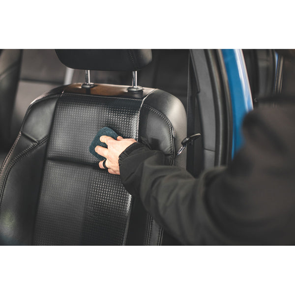 Using L1 Leather Guard AB leather protectant from Gtechniq on the black leather front seats of a blue Toyota Tacoma