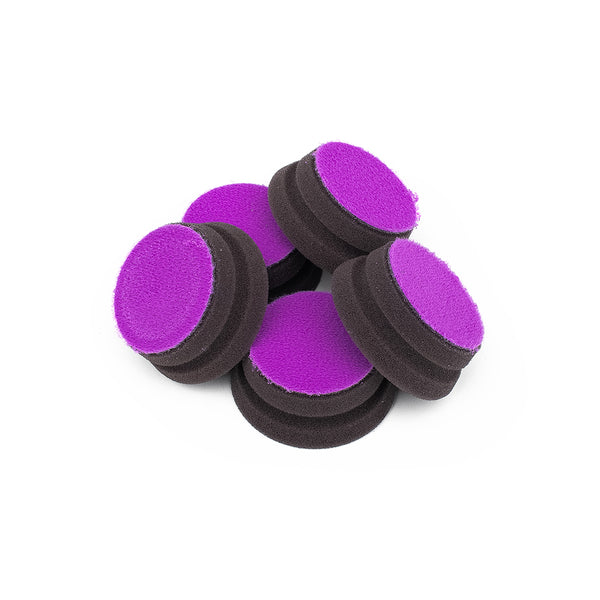 A pile of five purple Koch Chemie polishing pads on a white background.