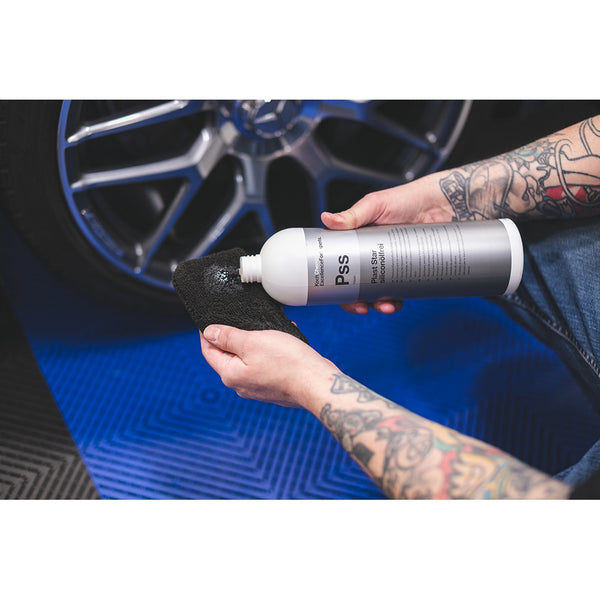 A closeup of a person pouring Koch Chemie Plast Star onto a black Terry Sponge.