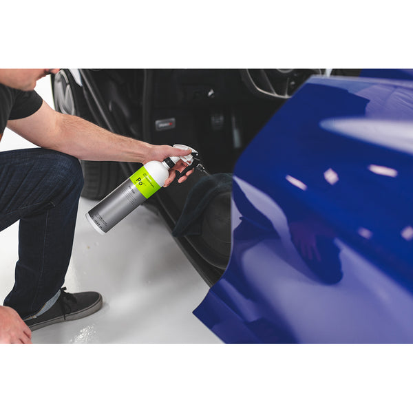 A closeup of a person spraying the floors of a car with Koch Chemie Pol Star.