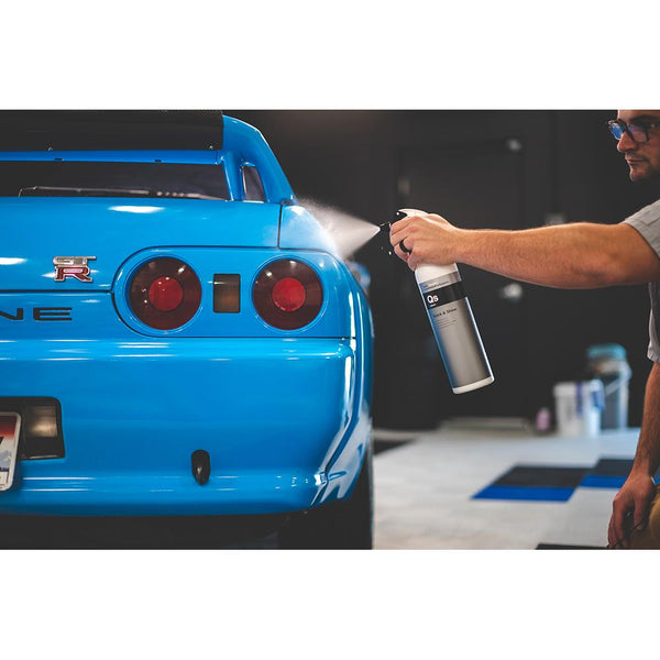 A person spraying a blue car with Koch Chemie Quick and Shine.