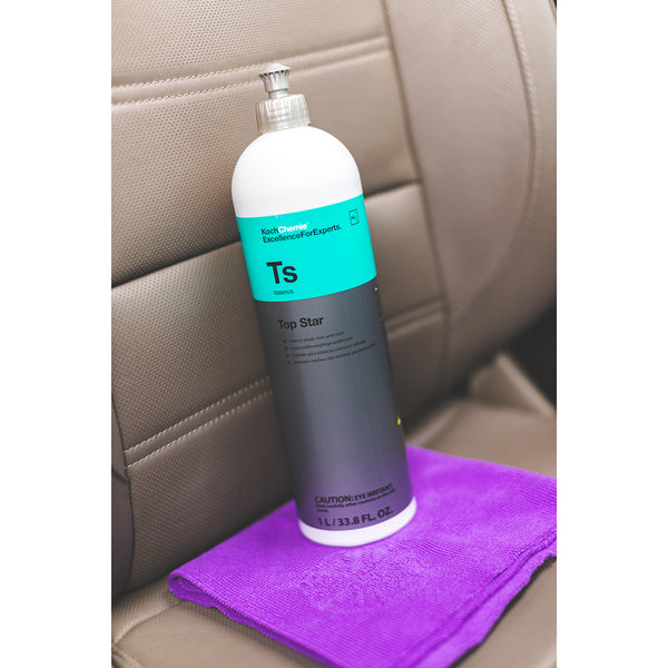 A bottle of Koch Chemie Top Star on a purple towel on a beige car seat.
