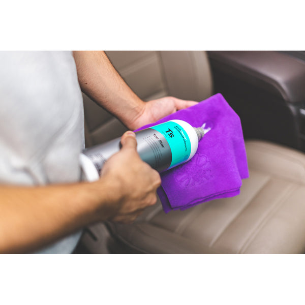 A closeup of someone pouring Koch Chemie Top Star on a purple towel.