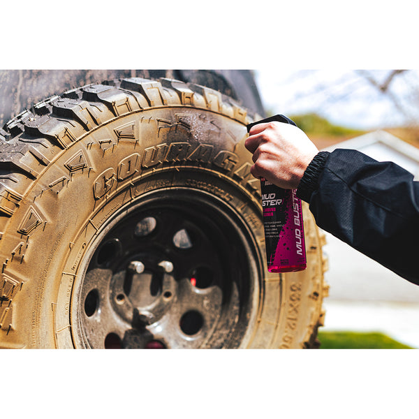 A closeup of a person spraying a dust covered tire with P&S Mud Buster.