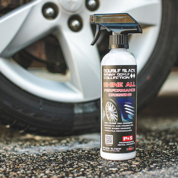 A spray bottle of P & S Shine All with a tire in the background.