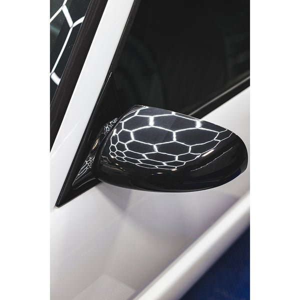 A white car's shiny side mirror .