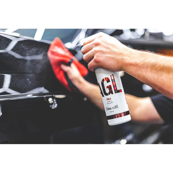 A person spraying the side of a car with Stjarnagloss Parla.