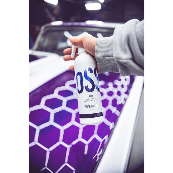 A closeup of a person spraying a purple car with Stjarnagloss Silke.