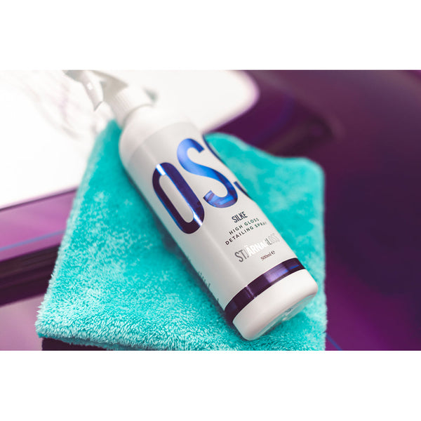A spray bottle of Stjarnagloss Silke on a teal towel on a purple car hood.
