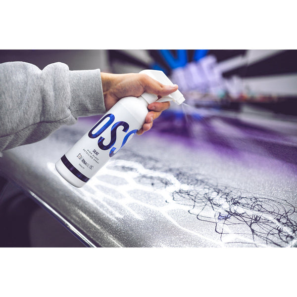 A closeup of a person spraying a purple car with Stjarnagloss Silke.