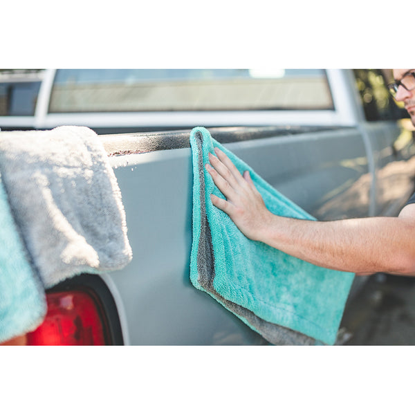 A closeup of a person scrubbing a truck with a liquid8r towel.