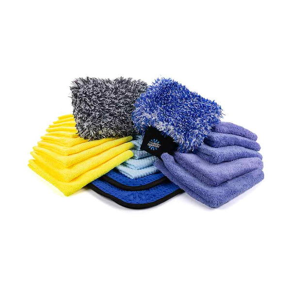 A collection of car detailing microfiber towels and mitts in various colors, including yellow, light blue, dark blue, purple, and gray. The set features folded towels, plush wash mitts, and a mix of fluffy and short-pile textures, neatly arranged to showcase the variety of detailing products for different cleaning tasks.